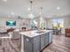 Open kitchen concept that flows into the living room with the kitchen island having barstool seating and a dining room to the right at 12650 Sunrise Dr, Noblesville, IN 46060