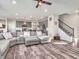 Open-concept living room featuring a large sectional sofa, hardwood floors, and modern gray kitchen with stainless steel appliances at 12650 Sunrise Dr, Noblesville, IN 46060