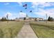 View of the community clubhouse with American flags flying out front on a beautiful day at 12819 Bardolino Dr, Fishers, IN 46037