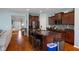 Open kitchen with dark cabinets, granite counters, and hardwood floors at 12819 Bardolino Dr, Fishers, IN 46037