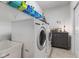 Well-equipped laundry room with modern washer and dryer units and storage shelves for supplies at 12819 Bardolino Dr, Fishers, IN 46037