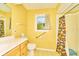 Yellow bathroom with tile floor, white vanity, and a walk-in shower at 13060 Wembly Cir, Carmel, IN 46033
