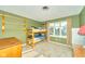 Green bedroom with a bunk bed, shelving, and a bright window view at 13060 Wembly Cir, Carmel, IN 46033