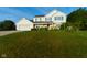 Traditional two-story home with white siding, green shutters and a well-manicured lawn and landscape at 13060 Wembly Cir, Carmel, IN 46033