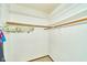 A walk-in closet with carpeted floor and white walls with ample shelf space at 13060 Wembly Cir, Carmel, IN 46033