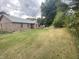 Large back yard with brick home, manicured lawn and wooded view for privacy at 145 Goodnight Rd, Martinsville, IN 46151