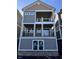 Three-story home featuring covered balconies on the upper two floors and a grey exterior with white trim at 15405 Mystic Rock Dr, Carmel, IN 46033