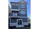Stylish three-story home with gray siding, white trim, and a balcony, designed for modern living at 15407 Mystic Rock Dr, Carmel, IN 46033