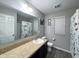 Bright bathroom featuring a granite vanity, toilet, and shower/tub combo with floral shower curtain at 1566 Dorset Dr, Avon, IN 46123