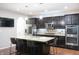 Modern kitchen featuring an island with seating, stainless appliances, and dark wood cabinetry at 1566 Dorset Dr, Avon, IN 46123