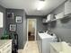 Bright laundry room featuring tile floors, gray paint, and modern white appliances at 1566 Dorset Dr, Avon, IN 46123