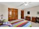 Cozy bedroom featuring a ceiling fan, wooden furniture, and warm color scheme at 1852 Lakeside Ln, Indianapolis, IN 46229
