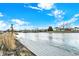 View of a wooden dock on the water, with a grassy lawn and some trees in the background at 1852 Lakeside Ln, Indianapolis, IN 46229