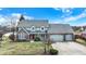 Charming two-story home with a well-manicured lawn and a welcoming red front door beneath a covered porch at 1852 Lakeside Ln, Indianapolis, IN 46229