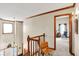 Bright hallway featuring a wooden banister, carpet flooring, and trim at 1852 Lakeside Ln, Indianapolis, IN 46229