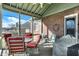 Cozy screened porch with brick accent walls, ceiling fan and comfortable outdoor seating at 1852 Lakeside Ln, Indianapolis, IN 46229