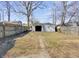 The backyard features a detached garage, patchy grass, and a small dirt path at 2014 Barth Ave, Indianapolis, IN 46203