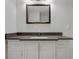 This bathroom features a vanity with a white cabinet, a dark countertop, and a square mirror at 2014 Barth Ave, Indianapolis, IN 46203