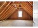 Spacious attic featuring unfinished floors, exposed beams, and a window for natural light at 20451 Chatham Hills Blvd, Westfield, IN 46074