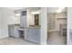 Bathroom with double sinks, granite countertops, grey cabinetry, and a walk-in closet at 20451 Chatham Hills Blvd, Westfield, IN 46074