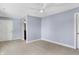 A bright bedroom with light-colored carpet, a ceiling fan, and a doorway to another room at 20451 Chatham Hills Blvd, Westfield, IN 46074