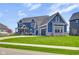 Charming blue two-story home with three-car garage and well-manicured lawn at 20451 Chatham Hills Blvd, Westfield, IN 46074