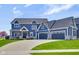 Beautiful two-story home with blue siding, stone accents, and a three-car garage at 20451 Chatham Hills Blvd, Westfield, IN 46074