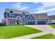 Charming two-story home with blue siding, stone accents, and a three-car garage at 20451 Chatham Hills Blvd, Westfield, IN 46074