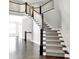 Grand foyer with staircase featuring dark wood trim, white risers, and decorative spindles at 20451 Chatham Hills Blvd, Westfield, IN 46074