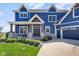 Inviting front porch with seating area and stone accents on a beautiful blue home at 20451 Chatham Hills Blvd, Westfield, IN 46074