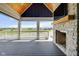 Cozy outdoor fireplace on a covered patio with views of the pond at 20451 Chatham Hills Blvd, Westfield, IN 46074
