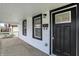 Close-up of the inviting front porch with white railings and a black front door with glass at 2137 Napoleon St, Indianapolis, IN 46203