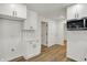 This bright kitchen features white cabinets, laminate floors, and stainless steel appliances at 2137 Napoleon St, Indianapolis, IN 46203