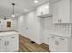 This kitchen has white cabinets, subway tile, quartz counters, and laminate floors at 2137 Napoleon St, Indianapolis, IN 46203