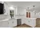 This kitchen is equipped with stainless steel appliances, white cabinets and quartz counters at 2137 Napoleon St, Indianapolis, IN 46203