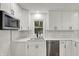 This kitchen is equipped with stainless steel appliances, white cabinets and quartz counters at 2137 Napoleon St, Indianapolis, IN 46203