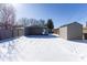 Backyard with a garage, storage shed, and snow-covered ground at 2306 Finley Ave, Indianapolis, IN 46203