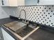 Close up on stainless sink with a black and white honeycomb backsplash at 2306 Finley Ave, Indianapolis, IN 46203