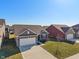 Areal view of a well kept one-story home featuring a brick facade, well-kept lawn, and an attached two-car garage at 293 Carrick Glen Blvd, Pendleton, IN 46064