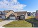 Attractive one-story home featuring a brick facade, well-kept lawn, and an attached two-car garage in a residential area at 293 Carrick Glen Blvd, Pendleton, IN 46064
