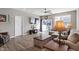 Cozy living room featuring wood-look floors, large windows, and a sliding glass door to a backyard patio at 293 Carrick Glen Blvd, Pendleton, IN 46064
