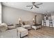 An open-concept living room boasts a ceiling fan, neutral colors, and wood-look flooring at 293 Carrick Glen Blvd, Pendleton, IN 46064