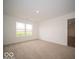 Spacious bedroom with tan carpet, white walls, and a window overlooking the backyard at 3261 W Keepsake Ln, Monrovia, IN 46157