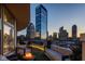 Cozy balcony featuring comfortable seating and a fire pit, complemented by the backdrop of the city skyline at dusk at 333 Massachusetts Ave # 801, Indianapolis, IN 46204