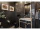 Modern powder room with black wallpaper and a unique marble sink with gold fixtures, creating a chic, upscale design at 333 Massachusetts Ave # 801, Indianapolis, IN 46204
