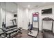 Bright home gym with treadmills, weight benches, mirrored wall, and mounted television for workout entertainment at 333 Massachusetts Ave # 801, Indianapolis, IN 46204