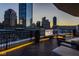 This rooftop deck features comfortable seating, a fire pit, a mounted TV, and stunning skyline views at 333 Massachusetts Ave # 801, Indianapolis, IN 46204