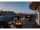 Rooftop deck featuring a cozy seating area with a fire pit and dining, showcasing city views at dusk at 333 Massachusetts Ave # 801, Indianapolis, IN 46204