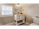 Bright bathroom featuring a round mirror, white vanity with storage, toilet, and patterned floor tiles at 342 E Minnesota St, Indianapolis, IN 46225