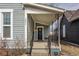 Charming covered front porch with black railings and a black front door at 342 E Minnesota St, Indianapolis, IN 46225